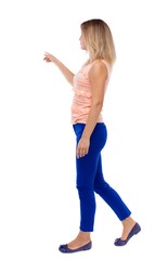 back view of pointing walking  woman. going girl pointing.  backside view of person.  Rear view people collection. Isolated over white background. blonde in blue pants is holding up his left hand to