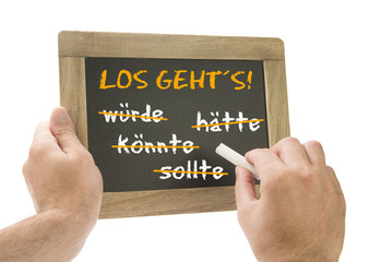 Los Geht´s! Hand schreibt auf Kreidetafel