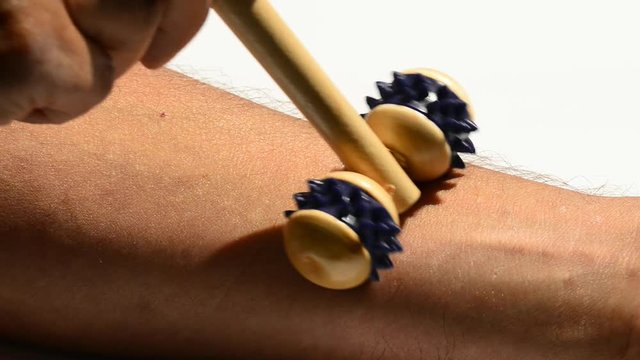 Chinesische Massage mit Roller an einer Hand