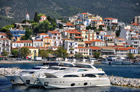 The port on the Greek island of Skiathos. Typical houses and taverns and beautiful luxury yacht.