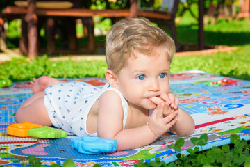 Baby boy crawling with finger in mouth