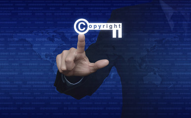 Businessman pressing copyright key icon over digital world map a