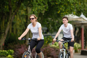 Obraz premium Healthy lifestyle - people riding bicycles in city park 