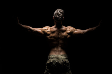 Muscular athlete bodybuilder man on a dark background