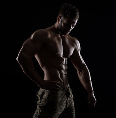 Fototapeta na wymiar Muscular athlete bodybuilder man on a dark background