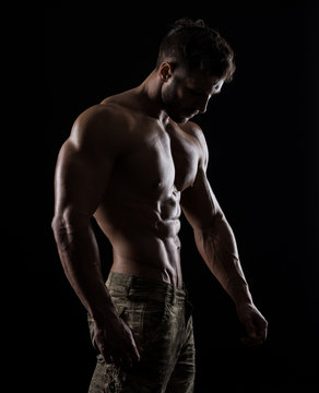 Muscular athlete bodybuilder man on a dark background