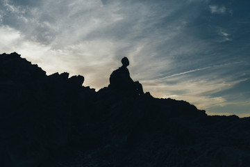 Back light silhouette of a man standing on a hill, overlooking