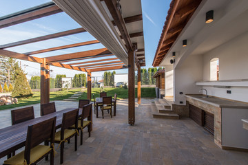 Beautiful terrace lounge with pergola and wooden table with chairs - 118001684