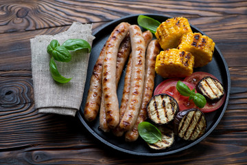 Frying pan with bbq sausages, eggplant, sweetcorn and tomato