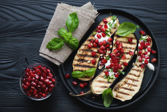 Grilled eggplant with sour cream, pomegranate and nuts