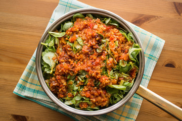 Purslane food with tomato sauce in a pan on a wicker.
