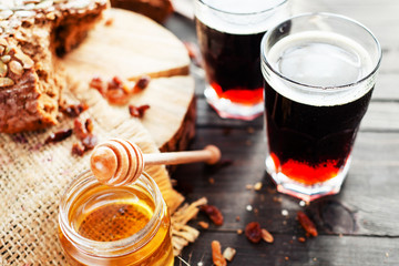 
summer and autumn cooling drink , kvass or  dark beer with honey , raisins and rye bread on a wooden background - obrazy, fototapety, plakaty