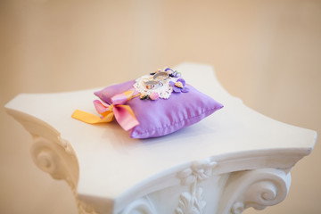 Golden wedding rings on decorated little purple pillow. Marriage concept