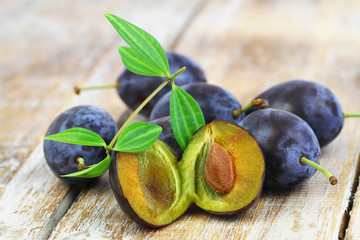Few juicy plums on rustic wooden surface, closeup
