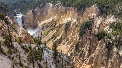 Big waterfall among the beautiful rocks. Mountain landscape. Stormy river flows in a narrow gorge. Lower falls from Uncle Toms Trail on The Grand Canyon of the Yellowstone National Park, Wyoming