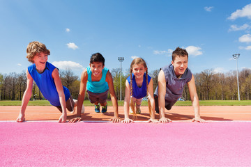 Happy teenagers doing push-up exercises outdoor