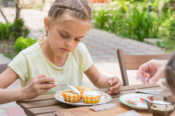The girl carefully coated with confectionery glaze Easter cupcakes