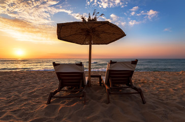 Sun loungers with an umbrella on the beach.