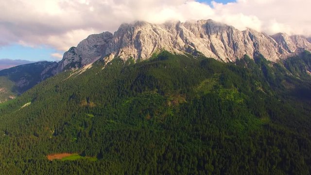 Camera flight over alpine landscape under Zugspitze peak. Grainau valley near Garmisch Partenkirchen. Amazing destination for hiking, skiing and mountaineering in Bavaria, Germany, Central Europe.