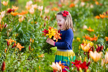 Little girl picking lilly flowers