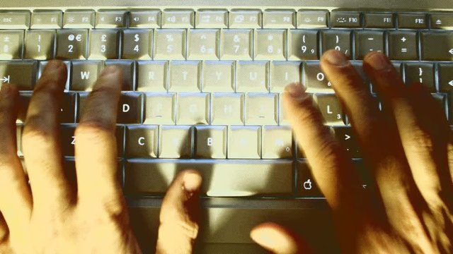 hands typing on a laptop keyboard