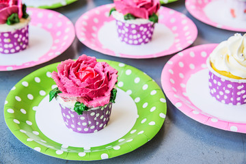 Rose cupcake with butter cream icing on grey background