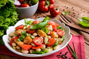  Vegetable salad with white beans, fried fish pieces, red pepper, green onion and chive