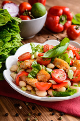 Vegetable salad with white beans, fried fish pieces, red pepper, green onion and chive