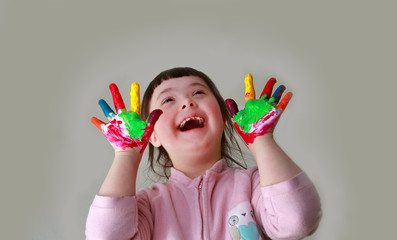 Cute little girl with painted hands. Isolated on grey background.