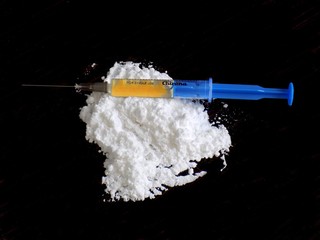 Injection on cocaine drug powder on black background