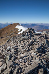 Scottish mountain covered in snow on a blue sunny day