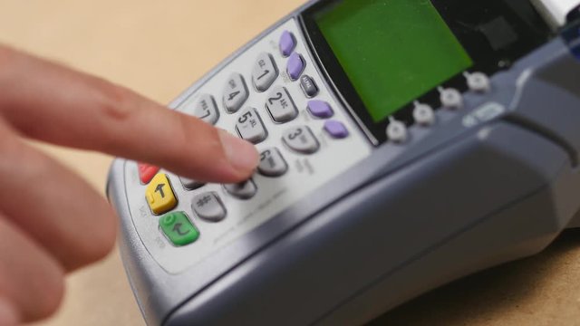 Paying with a credit card at a store. Credit card terminal being used to swipe the card and for entering the PIN number.