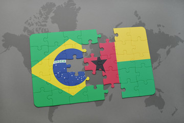 puzzle with the national flag of brazil and guinea bissau on a world map background.