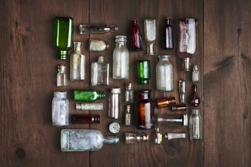 an assortment of vintage glass bottles on a wood background
