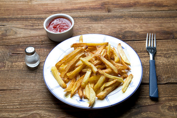 Smażone domowe frytki na drewnianym tle