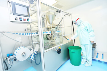 Worker inspecting quality of powder drug packaging