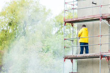 Obraz na płótnie Canvas Man cleaning wall. Scaffolding