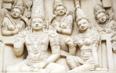Sculptural images of Shiva and Parvati in accompaniment of the retinue on the wall of an ancient...