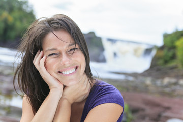 woman portrait in nature with waterfall on the back