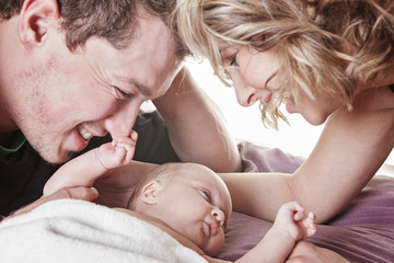 A beautiful couple with Baby on bed.