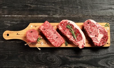 Photo sur Plexiglas Viande Matières premières fraîches steaks de boeuf Black Angus sur planche de bois