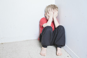 Neglected lonely child leaning at the wall