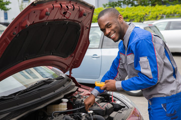 Mechanic Using Multimeter To Check Car Battery