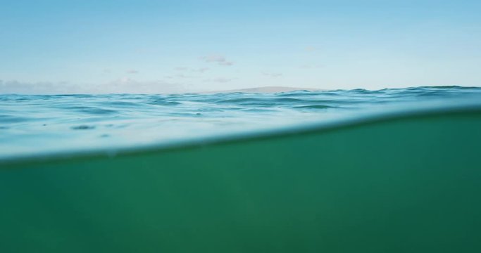 Beautiful blue ocean, over under split view of sky and underwater