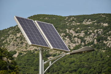 Solar panels on the streetlight collect the sun's energy with mountain in background