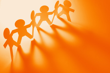 Team bonding together on orange background. Copy space