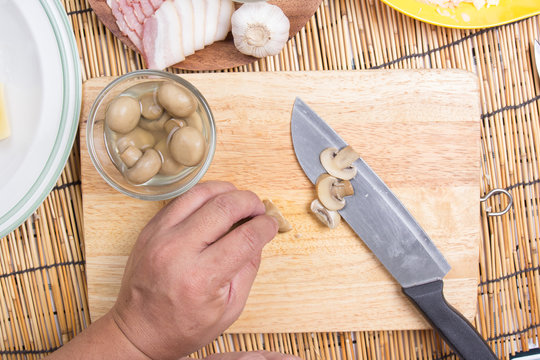 cutting mushroom with knife before cooking