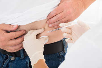 Doctor Injecting Stomach Of Diabetic Patient