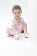 Fototapeta premium Smiling Positive Caucasian Ballerina Trying On Miniature Pointes