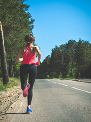 Young fitness woman running on forest trail. Runner athlete jogg